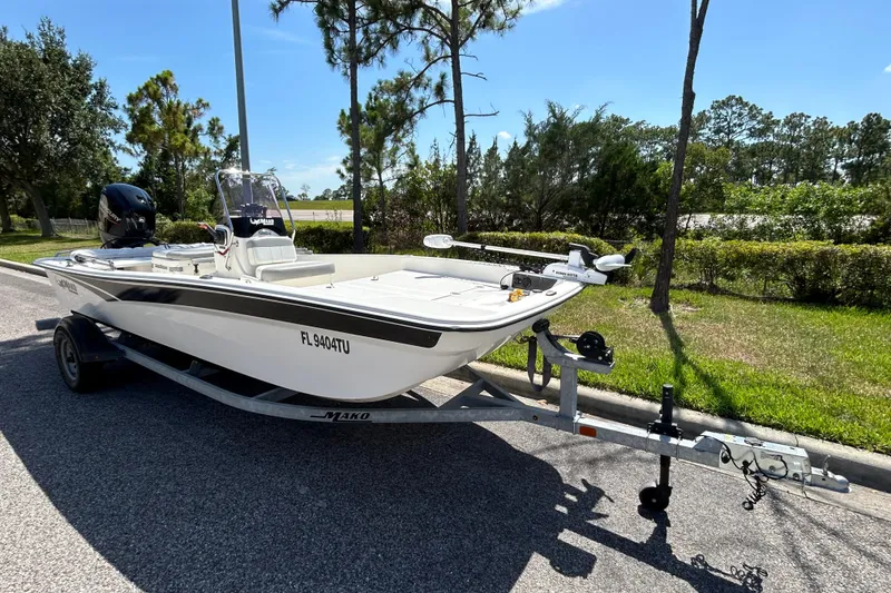 Slide: The Image of 2024 Mako Pro Skiff 17 CC boat on trailer, parked on roadside. - 1