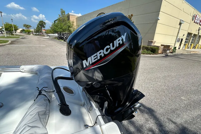 Slide: The Image of 2024 Mako Pro Skiff 17 CC with Mercury outboard motor in a parking lot. - 6