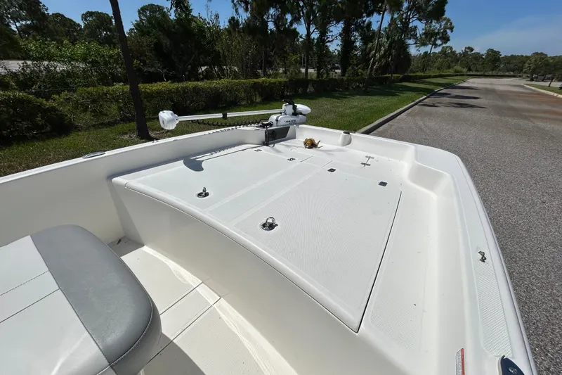 Slide: The Image of 2024 Mako Pro Skiff 17 CC boat deck with trolling motor, parked on a sunny day. - 9