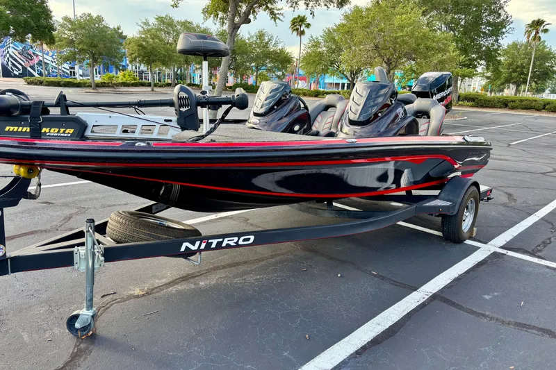 Slide: The Image of 2018 Nitro Z18 boat on trailer in parking lot, featuring sleek black and red design. - 1
