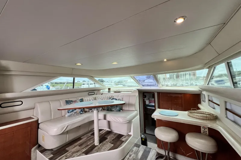 Slide: The Image of Luxurious interior of 1999 Sea Ray 420 Aft Cabin yacht with elegant seating and dining area. - 13