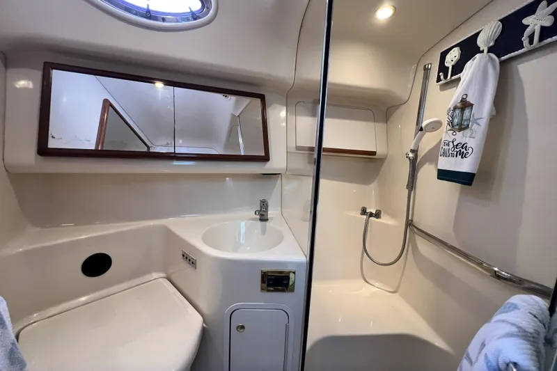 Slide: The Image of 1999 Sea Ray 420 Aft Cabin bathroom with shower, sink, and nautical decor. - 16