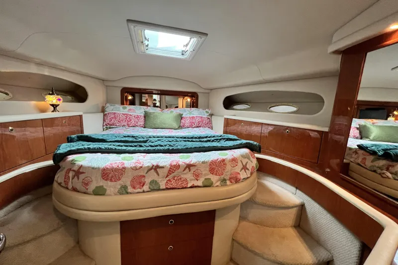 Slide: The Image of Luxurious 1999 Sea Ray 420 Aft Cabin bedroom with elegant bedding and wood accents. - 17