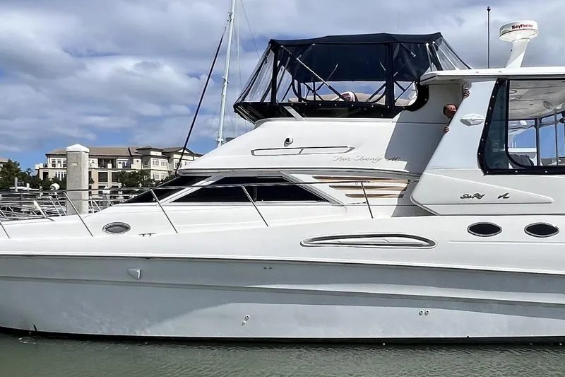 Slide: The Image of 1999 Sea Ray 420 Aft Cabin yacht docked at marina under cloudy sky. - 2