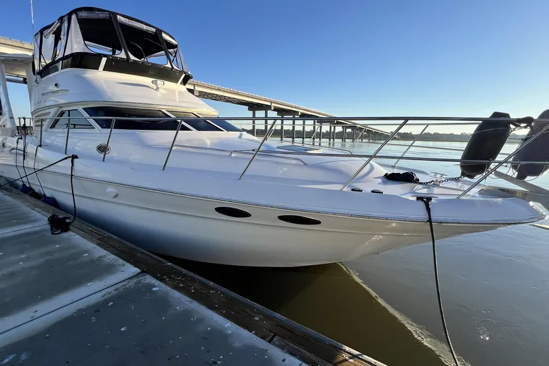 Slide: The Image of 1999 Sea Ray 420 Aft Cabin yacht docked by a bridge on a sunny day. - 7