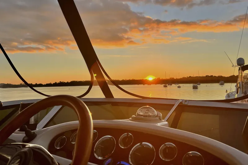 Slide: The Image of Sunset view from 1999 Sea Ray 420 Aft Cabin boat helm, overlooking calm waters. - 9