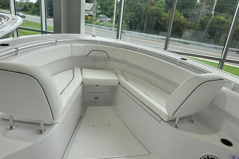 Slide: The Image of 2026 Sportsman Open 282 Center Console boat interior with white cushioned seating. - 4