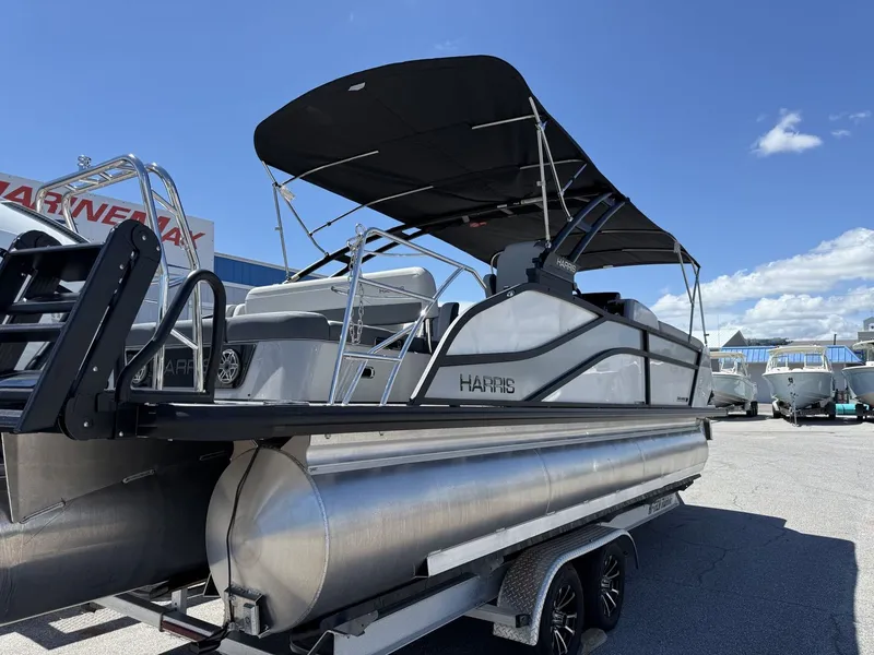 Slide: The Image of The image shows a Harris Grand Mariner 250 pontoon boat on a trailer under a blue sky. - 8