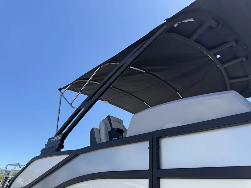 Slide: The Image of The image shows a modern pontoon boat with a black sunshade under a clear sky. - 16
