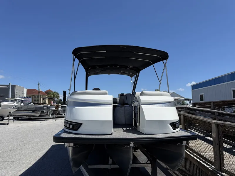 Slide: The Image of A 2027 Harris Grand Mariner 250 pontoon boat with a black canopy, parked in a lot. - 2