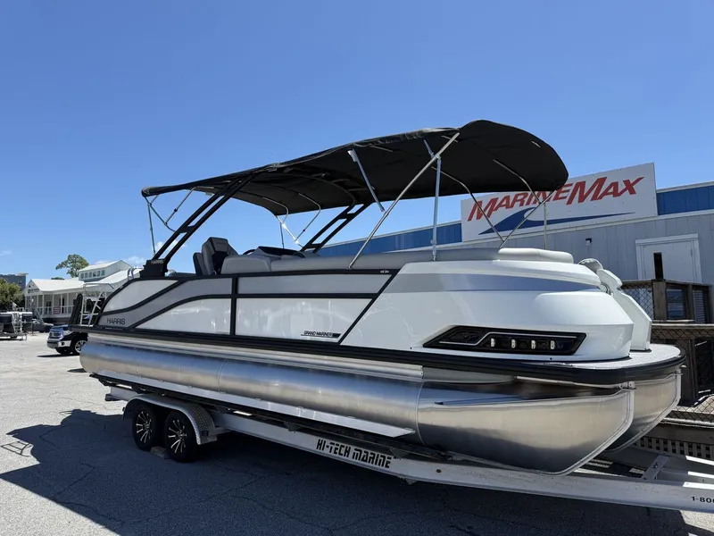 Slide: The Image of 2027 Harris Grand Mariner 250 on a trailer, featuring a black canopy and sleek design. - 1