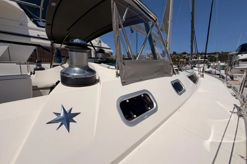 Slide: The Image of 1999 Jeanneau Sun Odyssey 45.2 sailboat deck with winch and star emblem in marina. - 11