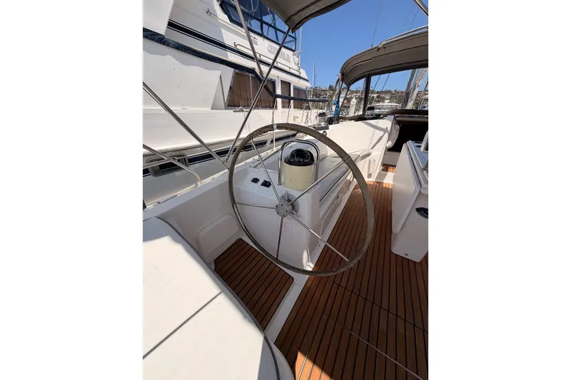Slide: The Image of Cockpit of 1999 Jeanneau Sun Odyssey 45.2 sailboat with wooden deck and steering wheel. - 28