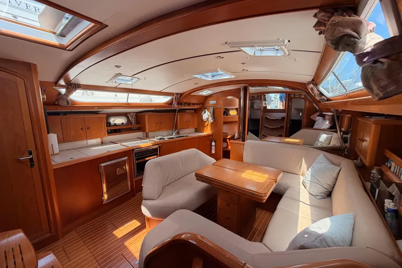 Slide: The Image of Interior of 1999 Jeanneau Sun Odyssey 45.2 yacht with cozy seating and wooden finishes. - 48