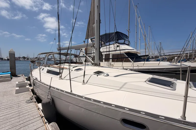 Slide: The Image of 1999 Jeanneau Sun Odyssey 45.2 sailboat docked at marina under clear blue sky. - 5