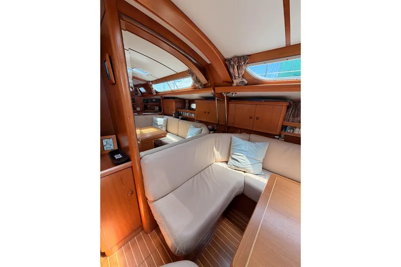 Slide: The Image of Interior of 1999 Jeanneau Sun Odyssey 45.2 yacht with cozy seating and wooden finishes. - 58