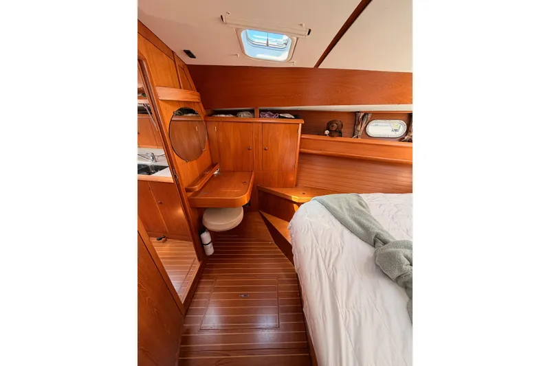 Slide: The Image of Interior of 1999 Jeanneau Sun Odyssey 45.2 yacht, featuring wooden cabinetry and cozy sleeping area. - 71