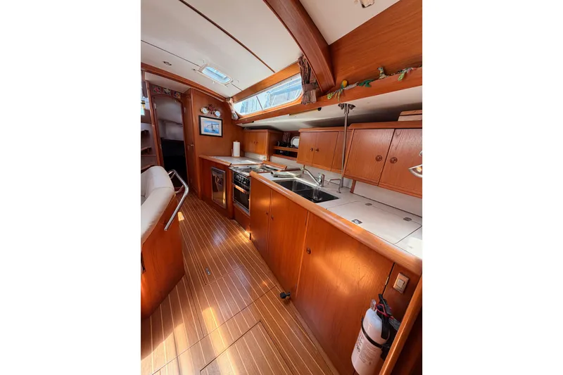 Slide: The Image of Interior of 1999 Jeanneau Sun Odyssey 45.2 yacht, featuring a wooden galley and modern amenities. - 73