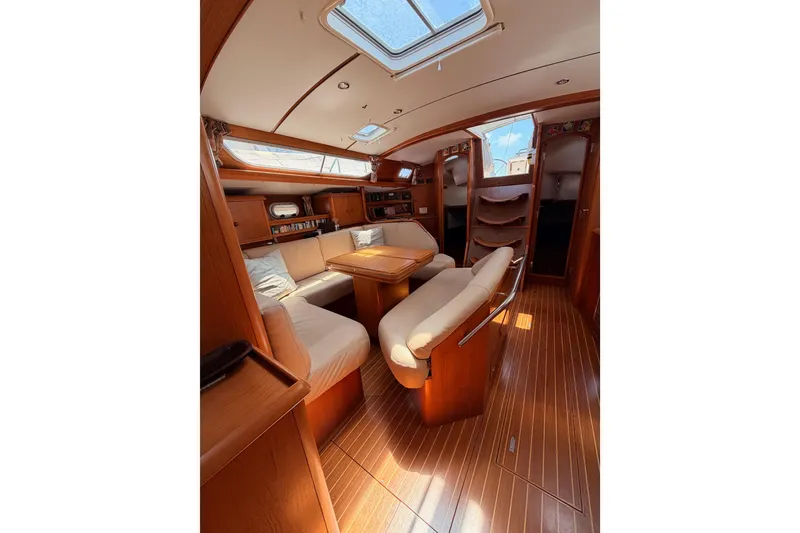 Slide: The Image of Interior of 1999 Jeanneau Sun Odyssey 45.2 yacht with elegant wood finish and seating area. - 74
