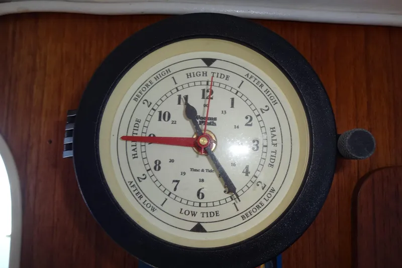 Slide: The Image of Tide clock on 1996 Lagoon 35 CCC yacht, indicating high and low tide times. - 100