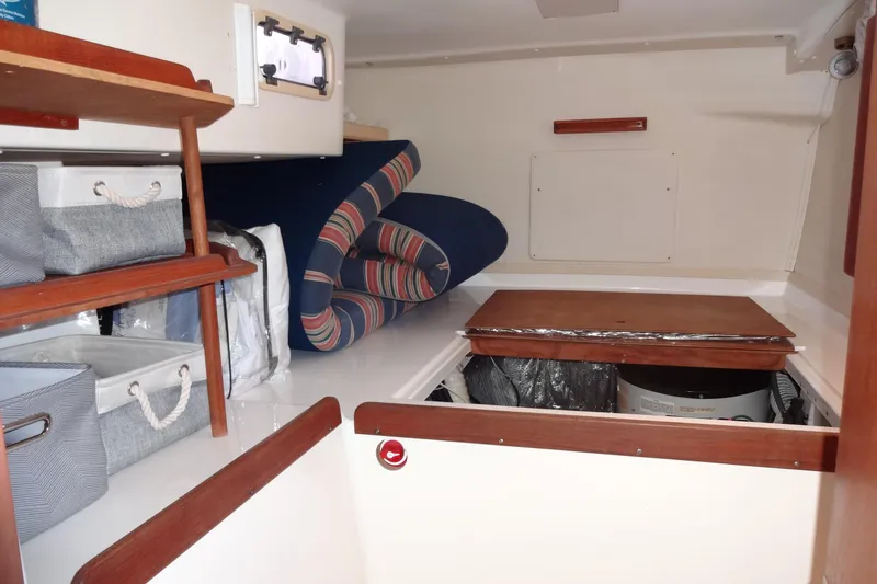 Slide: The Image of Interior storage area of a 1996 Lagoon 35 CCC boat with shelves and cushions. - 104