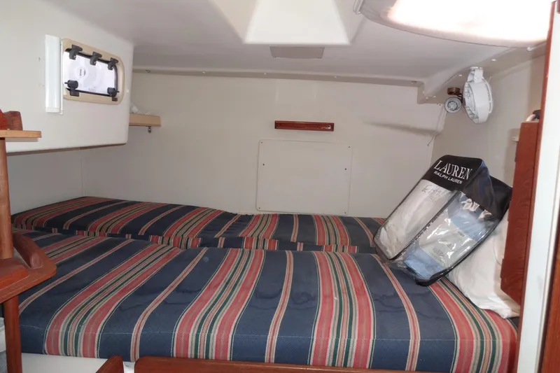 Slide: The Image of Interior cabin of 1996 Lagoon 35 CCC yacht with striped bedding and storage. - 111
