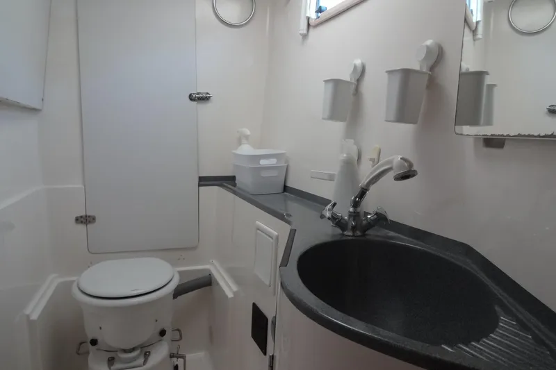 Slide: The Image of Bathroom interior of a 1996 Lagoon 35 CCC yacht, featuring a toilet and sink. - 124