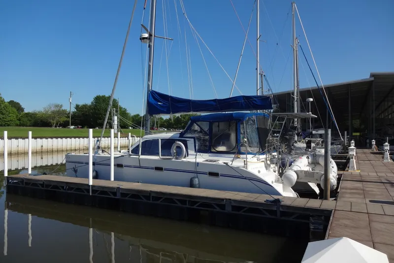 Slide: The Image of 1996 Lagoon 35 CCC catamaran docked at marina under clear blue sky. - 16
