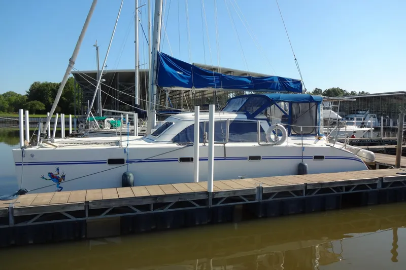Slide: The Image of 1996 Lagoon 35 CCC catamaran docked at marina with blue canopy. - 18