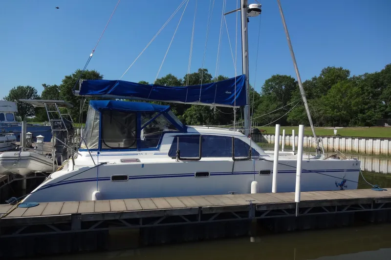 Slide: The Image of 1996 Lagoon 35 CCC catamaran docked at marina with blue canopy. - 23