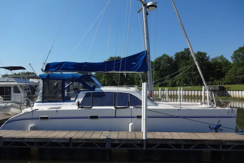 Slide: The Image of 1996 Lagoon 35 CCC catamaran docked, featuring blue sail cover and clear skies. - 24