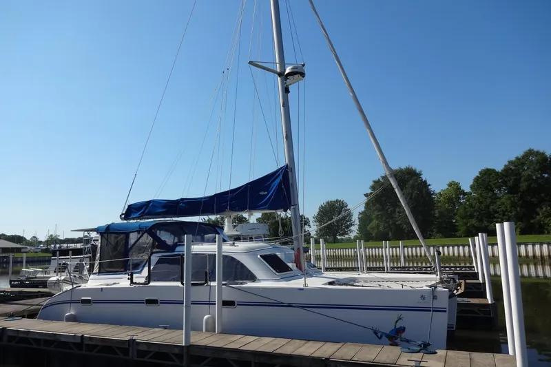 Slide: The Image of 1996 Lagoon 35 CCC catamaran docked at marina under clear blue sky. - 26