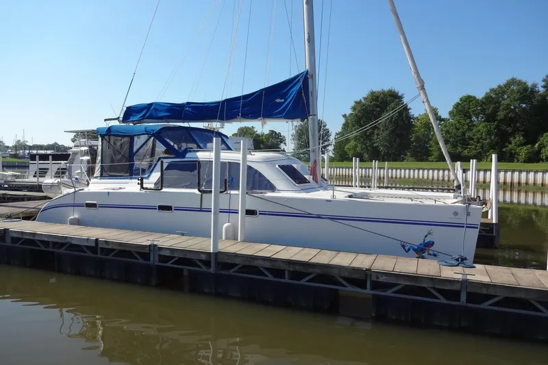 Slide: The Image of 1996 Lagoon 35 CCC catamaran docked at marina with blue canopy. - 27