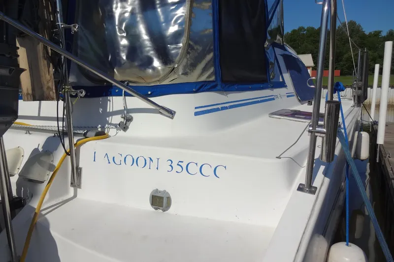 Slide: The Image of 1996 Lagoon 35 CCC sailboat docked, featuring blue accents and protective canopy. - 28