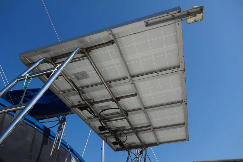 Slide: The Image of Solar panels mounted on a 1996 Lagoon 35 CCC catamaran under a clear blue sky. - 51