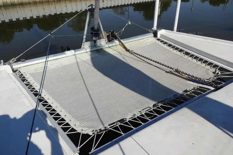 Slide: The Image of Trampoline netting on a 1996 Lagoon 35 CCC catamaran, docked by calm waters. - 57
