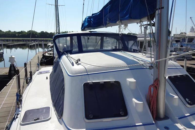 Slide: The Image of 1996 Lagoon 35 CCC sailboat docked at marina, featuring blue canopy and sleek design. - 58