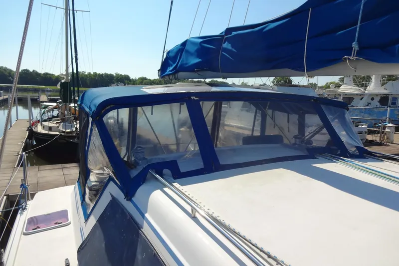Slide: The Image of Sailboat Lagoon 35 CCC, 1996 model, docked with blue canopy and clear windows. - 59