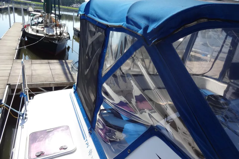 Slide: The Image of Lagoon 35 CCC sailboat from 1996 docked with blue canopy and clear windows. - 60