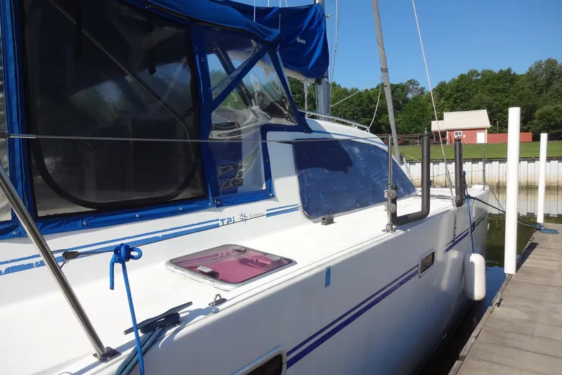 Slide: The Image of 1996 Lagoon 35 CCC sailboat docked, featuring blue accents and a spacious deck. - 63