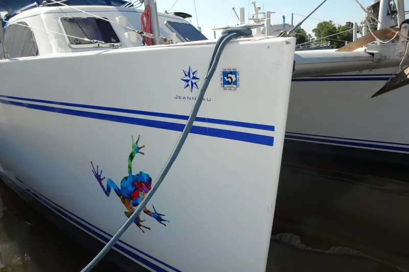 Slide: The Image of 1996 Lagoon 35 CCC sailboat with colorful frog design and blue stripes. - 65
