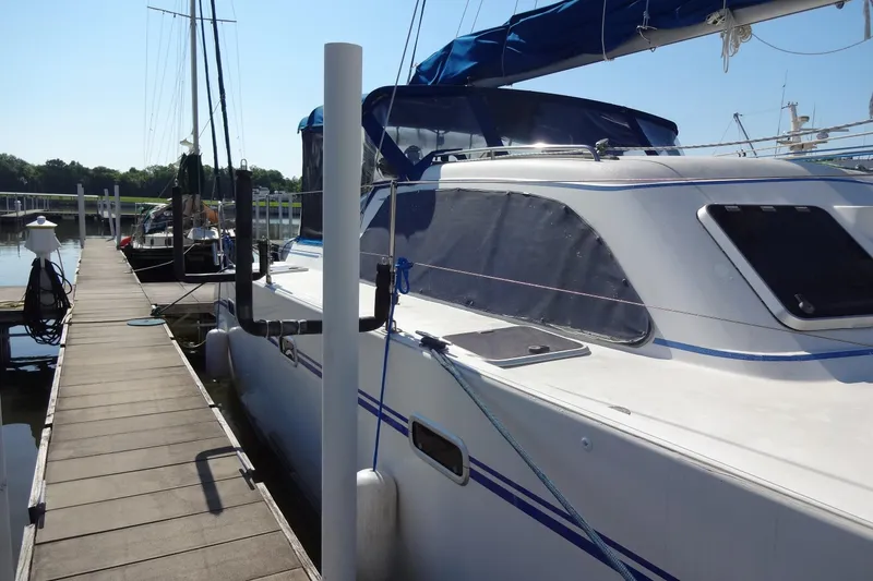Slide: The Image of 1996 Lagoon 35 CCC catamaran docked at a marina, featuring sleek design and blue accents. - 66