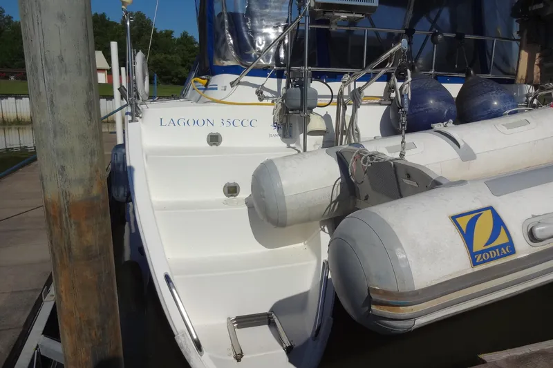 Slide: The Image of 1996 Lagoon 35 CCC catamaran docked with Zodiac inflatable boat attached. - 68