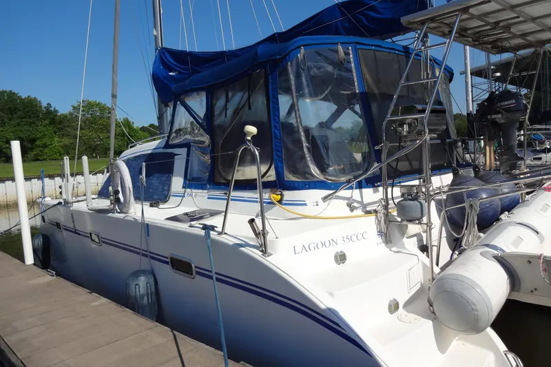 Slide: The Image of Sailboat Lagoon 35 CCC, 1996 model, docked with blue canopy and visible Yamaha motor. - 71