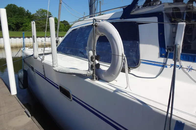 Slide: The Image of 1996 Lagoon 35 CCC sailboat docked, featuring a lifebuoy and protective railings. - 72