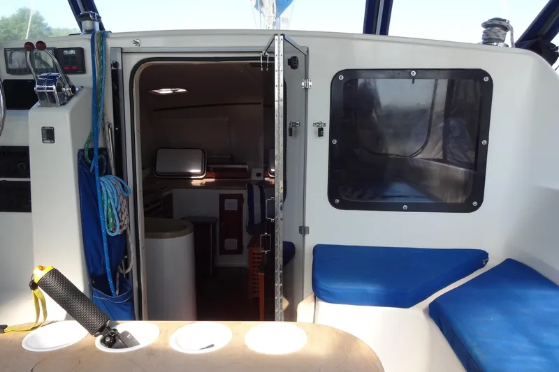 Slide: The Image of Interior view of a 1996 Lagoon 35 CCC sailboat, featuring seating and cabin entrance. - 77