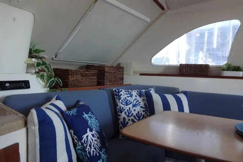 Slide: The Image of Interior of 1996 Lagoon 35 CCC yacht with cozy seating and nautical-themed pillows. - 96