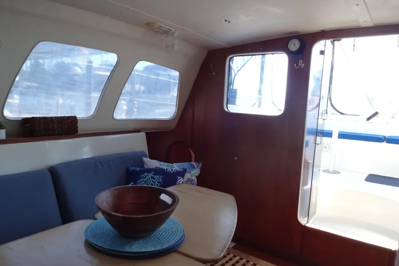 Slide: The Image of Interior of 1996 Lagoon 35 CCC catamaran with cozy seating and wooden accents. - 97