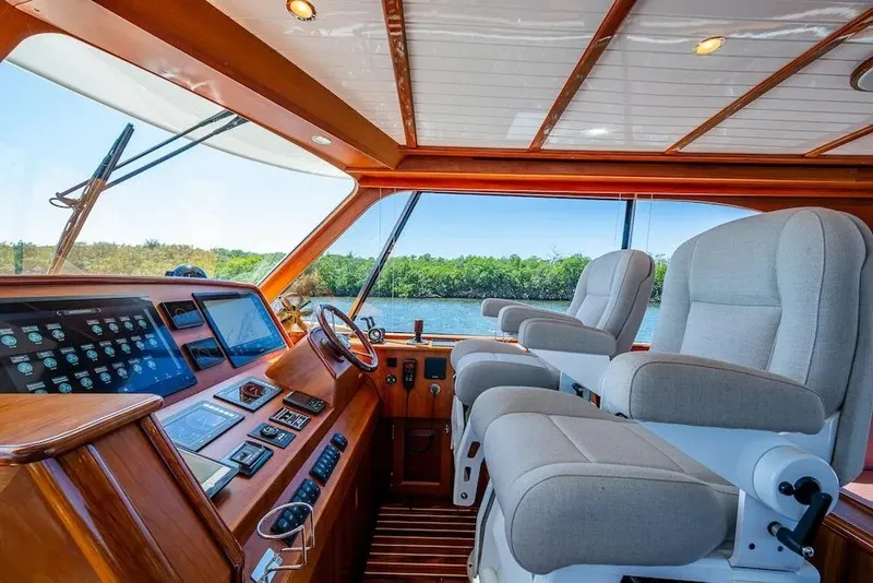 Slide: The Image of Luxurious helm of 2021 Hinckley Talaria 55 Flybridge MKII with plush seating and advanced controls. - 23
