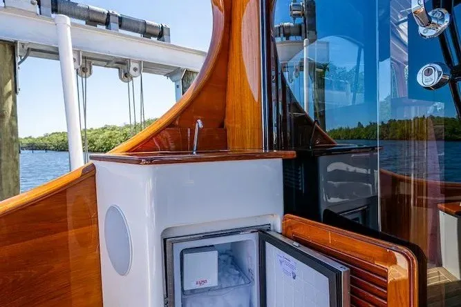 Slide: The Image of Hinckley Talaria 55 Flybridge MKII 2021 yacht interior with open mini fridge and wooden accents. - 13